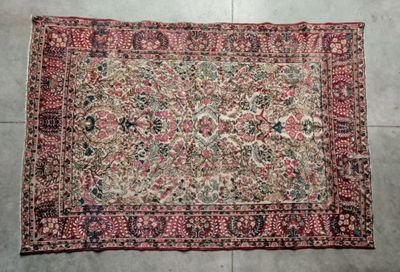 un tapis persan ancien posé sur un sol carrelé