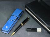 a pen, notebook, and pen case on a table