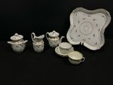 Plusieurs pièces de porcelaine sont posées sur une surface noire.