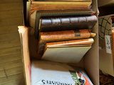 une pile de livres posée sur une chaise dans une pièce