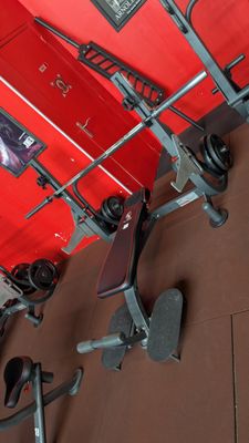 a gym equipment set up in a room with a red wall