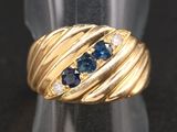 gros plan d'une bague en or avec saphirs bleus et diamants