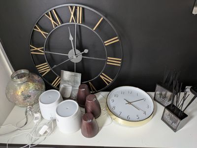 une horloge accrochée au mur à côté de quelques tasses