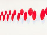 red dots are arranged in a row on a white wall