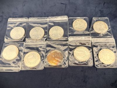 six different types of gold coins in plastic bags on a table