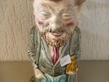 une figurine en céramique représentant un homme en train de lire un livre
