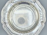 an antique silver plate on a table with a black background