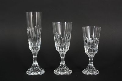 three crystal wine glasses sitting on top of a black table