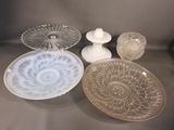 several glass dishes and vases on a table with a gray background