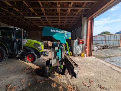 un tracteur garé dans un garage à côté d'un bulldozer