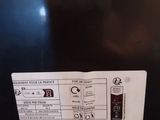 the back of a black refrigerator with a label on it