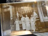 an old photo of a group of people standing in front of a store