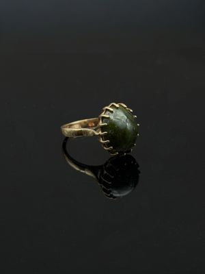 une bague en or avec une pierre de jade verte au centre