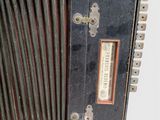 an old black accordion sitting on top of a white surface