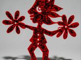 red and black paper cut sculpture of a man holding flowers