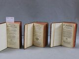 trois livres ouverts posés les uns à côté des autres sur une table