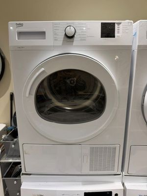 deux lave-linge et un sèche-linge empilés les uns sur les autres