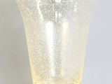vase en verre jaune à la surface mouchetée de blanc