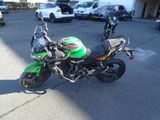 une moto verte et noire garée sur un parking