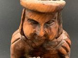 wooden statue of a gnome with a hat and holding a bowl