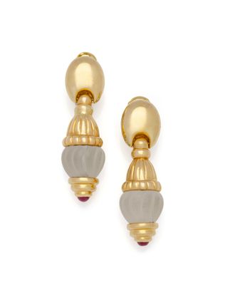 Les boucles d'oreilles dorées et grises sont superposées.