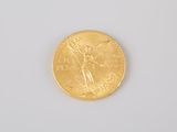 a close up of a gold coin on a white surface