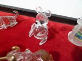 plusieurs figurines en verre représentant des animaux, posées sur une nappe rouge