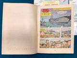 a book open to a comic book with a picture of a ship in the background