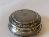 a silver plate with a silver lid on a white surface