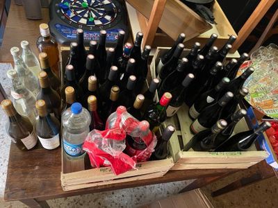 plusieurs bouteilles de vin posées sur une table, avec une fléchette en arrière-plan
