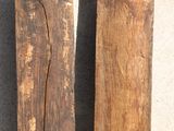 two pieces of wood sitting on the ground next to each other