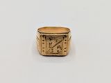 an image of a gold signet ring on a white surface
