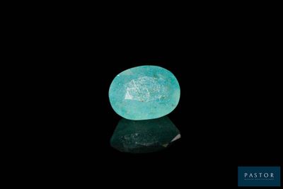 an oval aquamarinee stone on a black surface