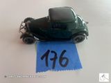 une petite voiture verte ornée d'un ruban bleu