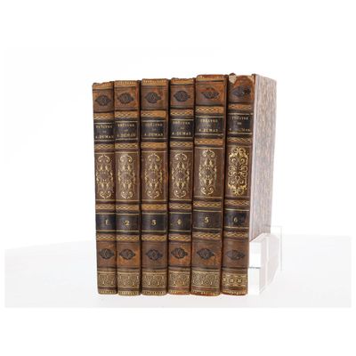 un coffret de trois livres à couverture marron et bordures dorées