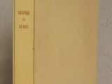 an old book sitting on top of a table next to a white wall