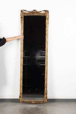 une femme debout près d'un grand miroir dans une pièce