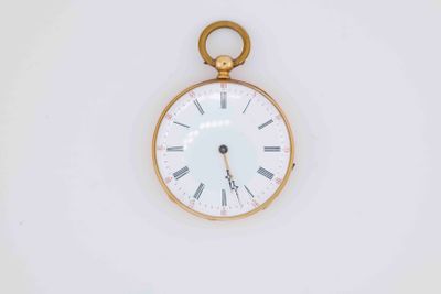 a gold pocket watch with roman numerals on the face