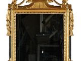 un miroir avec un cadre doré et une horloge dessus