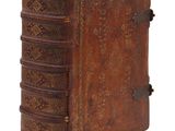 un vieux livre relié en cuir, orné de motifs élaborés sur la couverture et les tranches