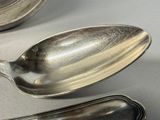 two spoons and a spoon rest on a table