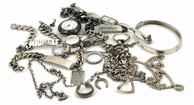 a pile of assorted silver jewelry on a white surface