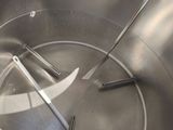stainless steel mixing bowl with spatulas and tongs inside of it