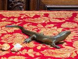 une statue de lézard posée sur une nappe rouge