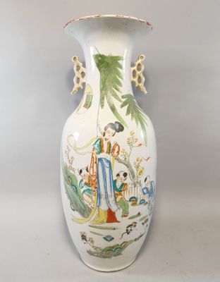 a white vase with a painting on it sitting on a table