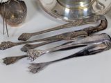 a lot of silver spoons and spoons on the table