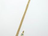 a gold necklace with a turquoise stone and a gold chain