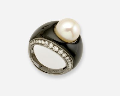 un gros plan d'une bague ornée d'une perle et de diamants