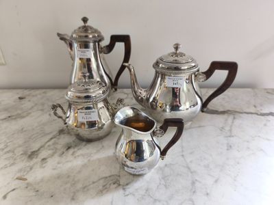 trois théières en argent posées sur une table en marbre