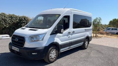 la camionnette blanche est garée sur le parking à côté des arbres